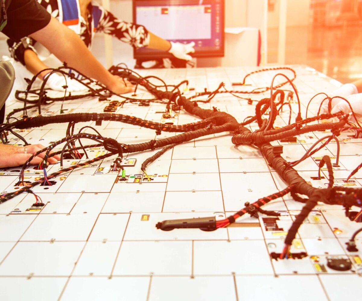 cable harness on table, engineers working