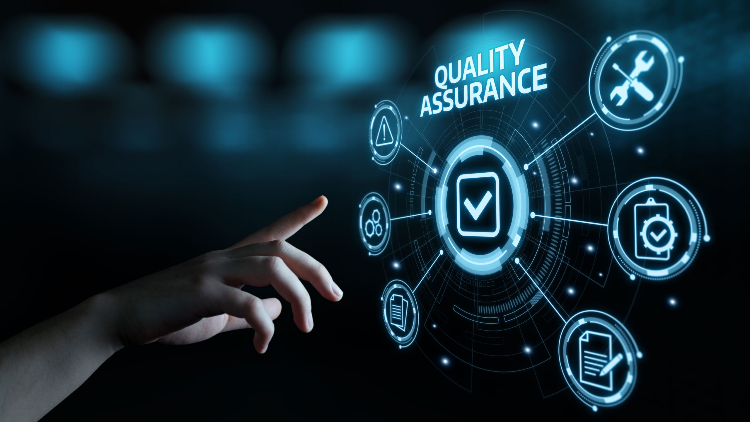 Hand pointing to a digital interface with quality assurance icons.